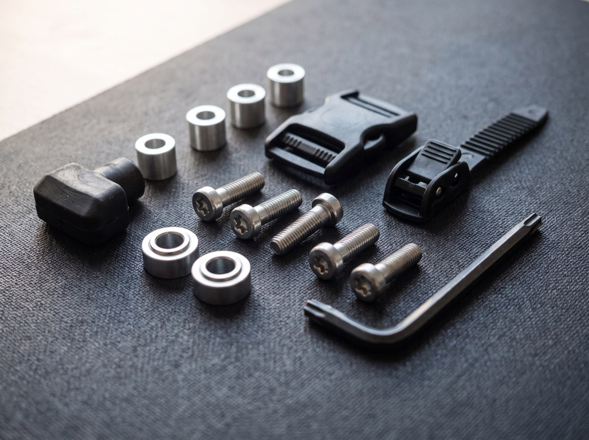 Achsschrauben, Spacer, Bremsstopper und Schnallen für Inline-Skates neben einem Torx-Schlüssel